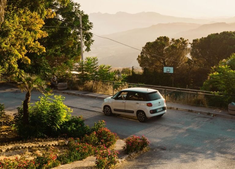 auto parcheggiata con paesaggio siciliano sullo sfondo