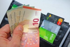carte di pagamento con soldi in mano