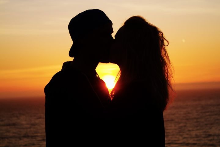 coppia che si bacia al tramonto romantico