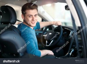 giovane guidatore al volante dellauto nuova