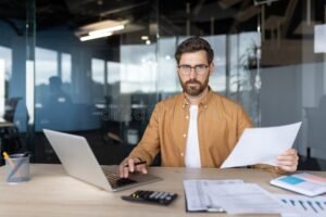 imprenditore con laptop e documenti finanziari