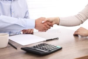 mani che si stringono sopra un tavolo bancario