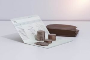 monete accanto a un libretto bancario aperto
