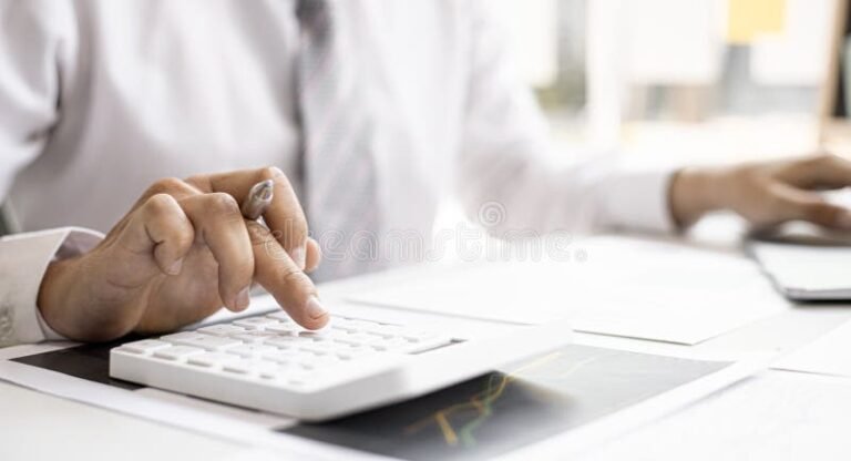 persona che calcola paghe con calcolatrice e documenti