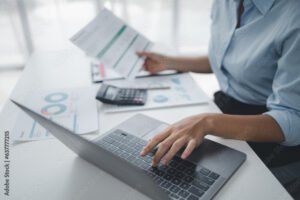 persona che controlla documenti finanziari al computer
