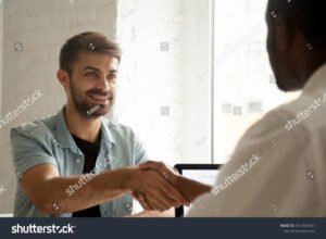persona sorridente che stringe una mano fiduciosa