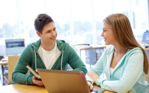 studenti felici con laptop e libri