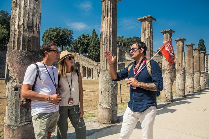turisti con guida davanti rovine antiche